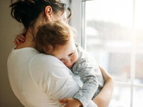 Una mamá abrazando a su hijo luego de un episodio de vómito en bebés Una mamá abrazando a su hijo luego de un episodio de vómito en bebés